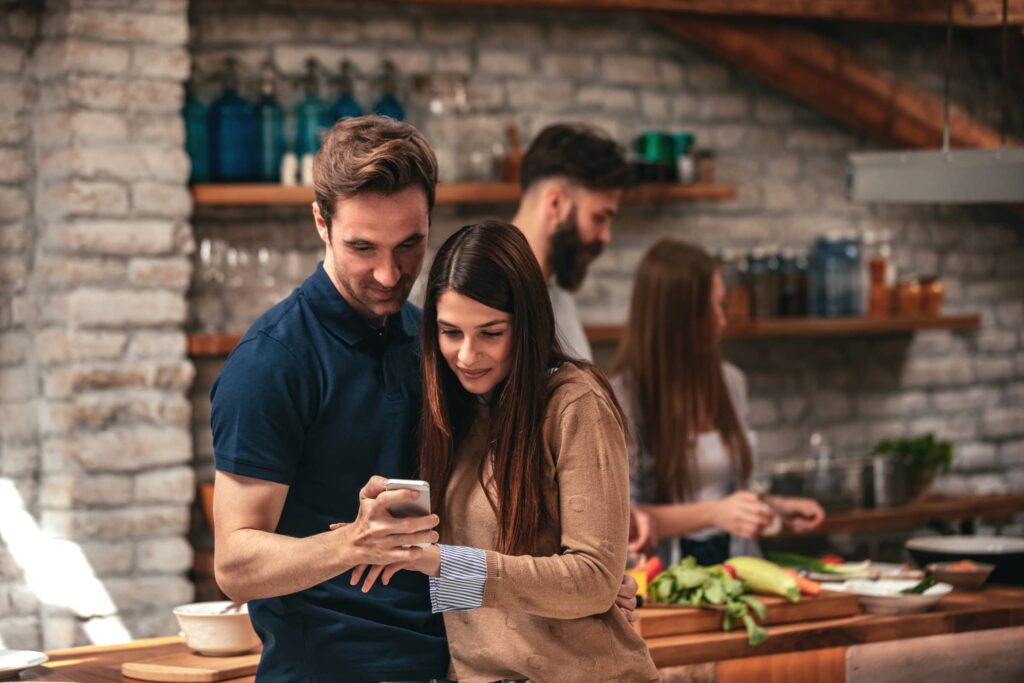 Couple hugging and looking at mobile phone.