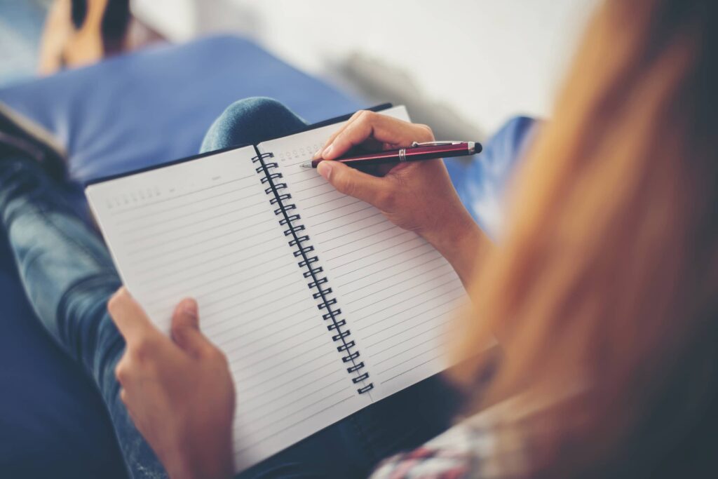 Woman writing in notebook.