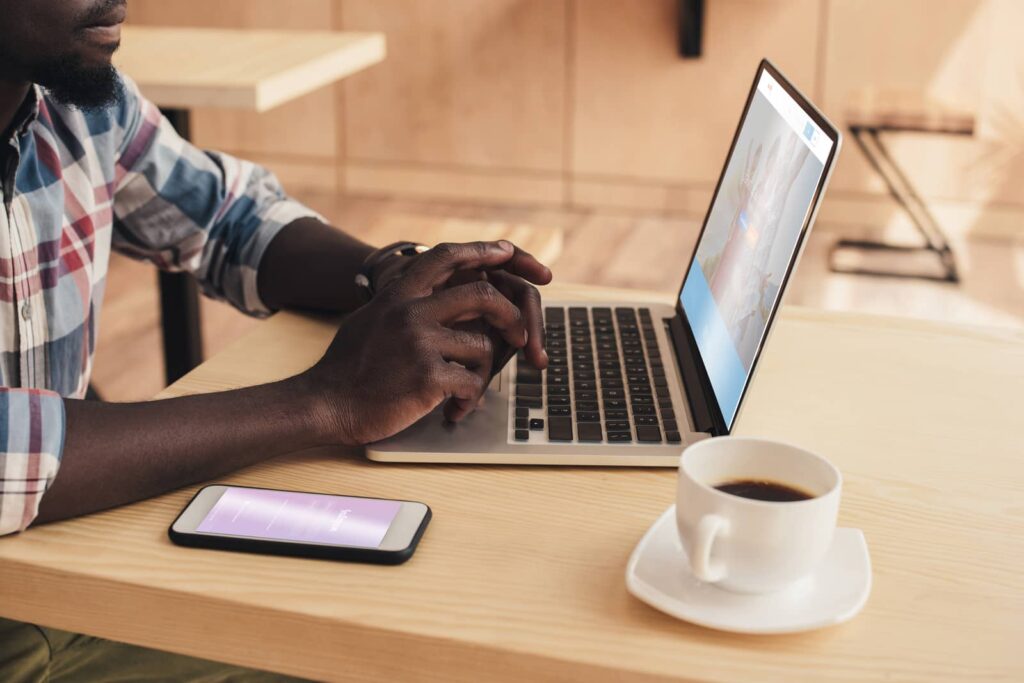 How to unblock someone on Instagram. Black man working on computer.