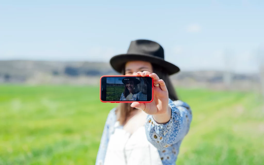 A woman taking a selfie to post on Instagram Story