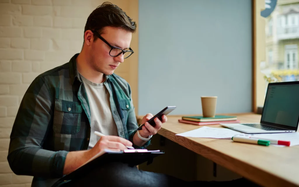 Young man reading on smartphone before repurposing content