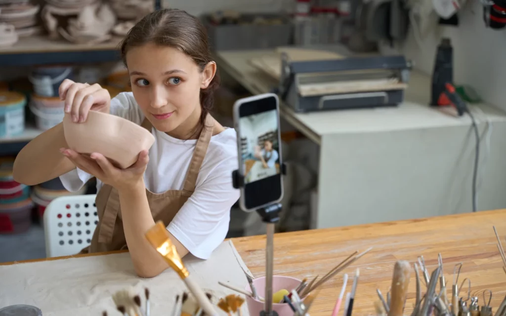 Young student sculpts a plate and takes a selfie