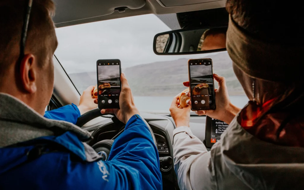 Two people recording a video inside a car