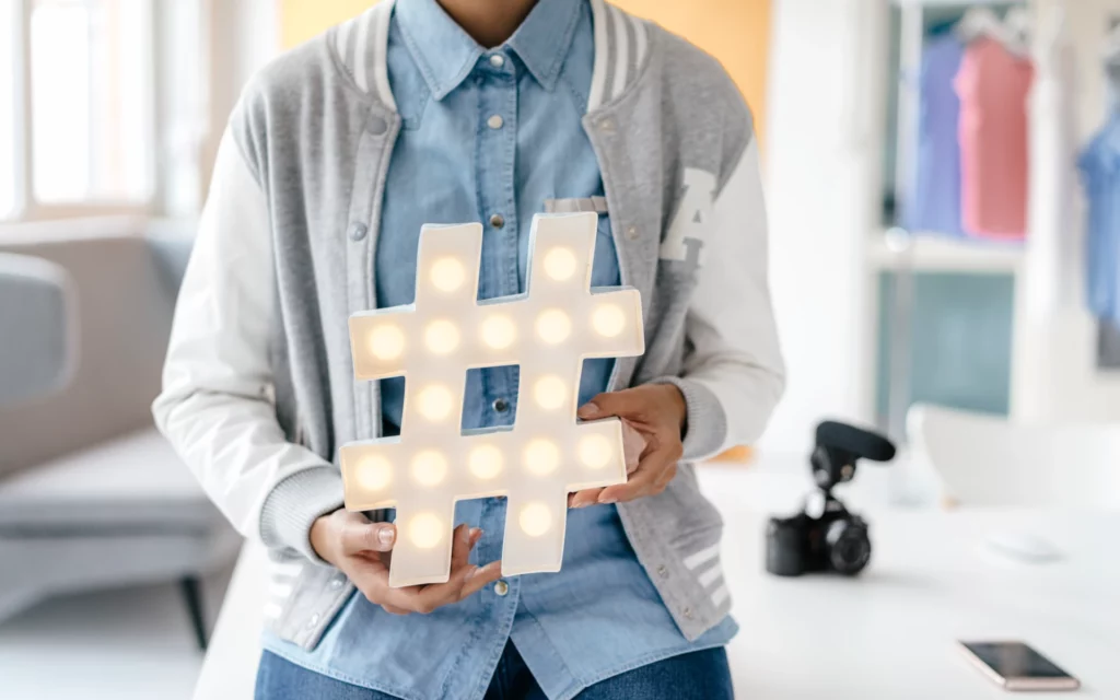 Young woman holding a hashtag sign