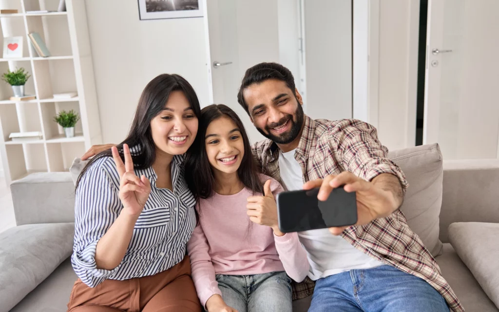 A family taking a selfie on their mobile device.