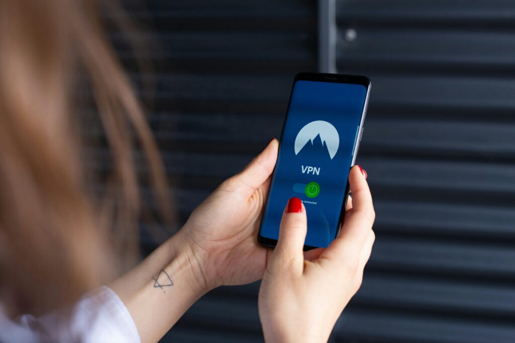 Woman holding a phone with visible VPN service screen.