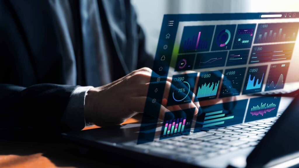 Person using a laptop with digital analytics dashboards and automation data overlays