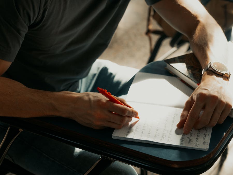 Focused student writing notes in a notebook during class.