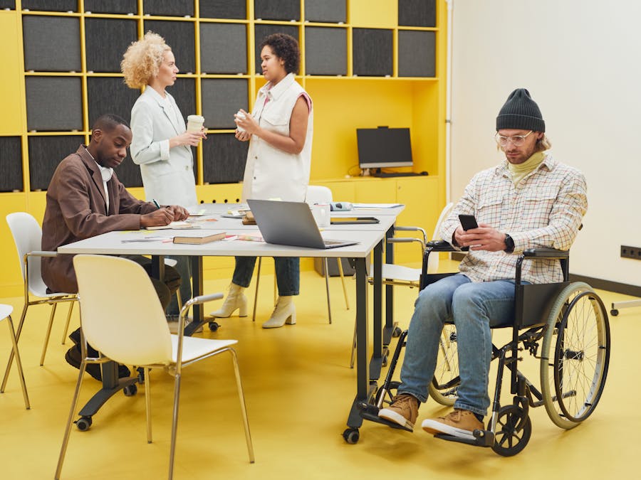 A diverse office team collaborating indoors, showcasing teamwork and inclusivity.