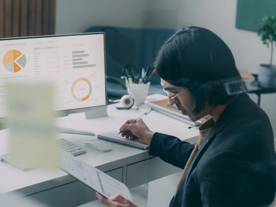 Business person reviewing analytics and charts at a modern office desk.