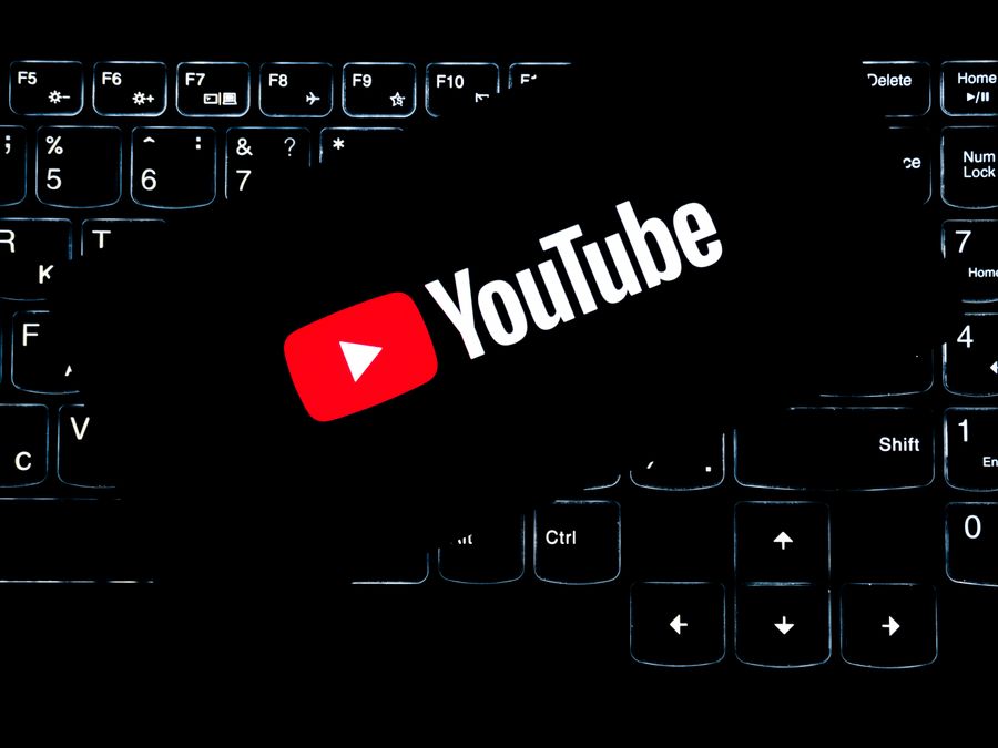 YouTube logo displayed on a backlit keyboard, representing digital media and online content creation.