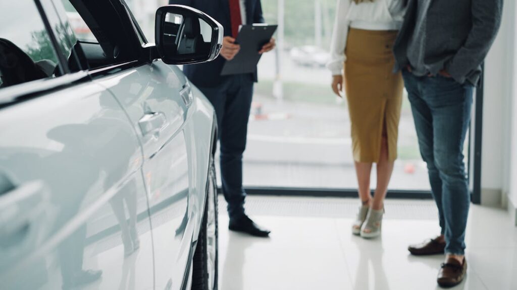 Professional consultation at a car dealership with businesspeople discussing car options.