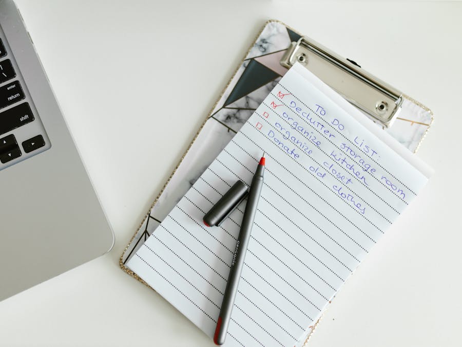 A neatly organized to-do list on a clipboard next to a laptop and pen, conveying productivity.