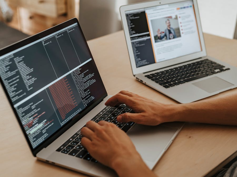 A developer working on a laptop, typing code, showcasing programming and technology skills.
