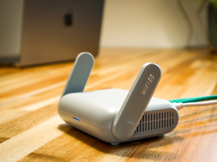 A sleek WiFi 6 router with antennas and cable on a wooden desk, perfect for modern home networks.
