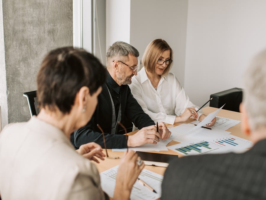 Team of professionals in office analyzing financial documents for business strategy.