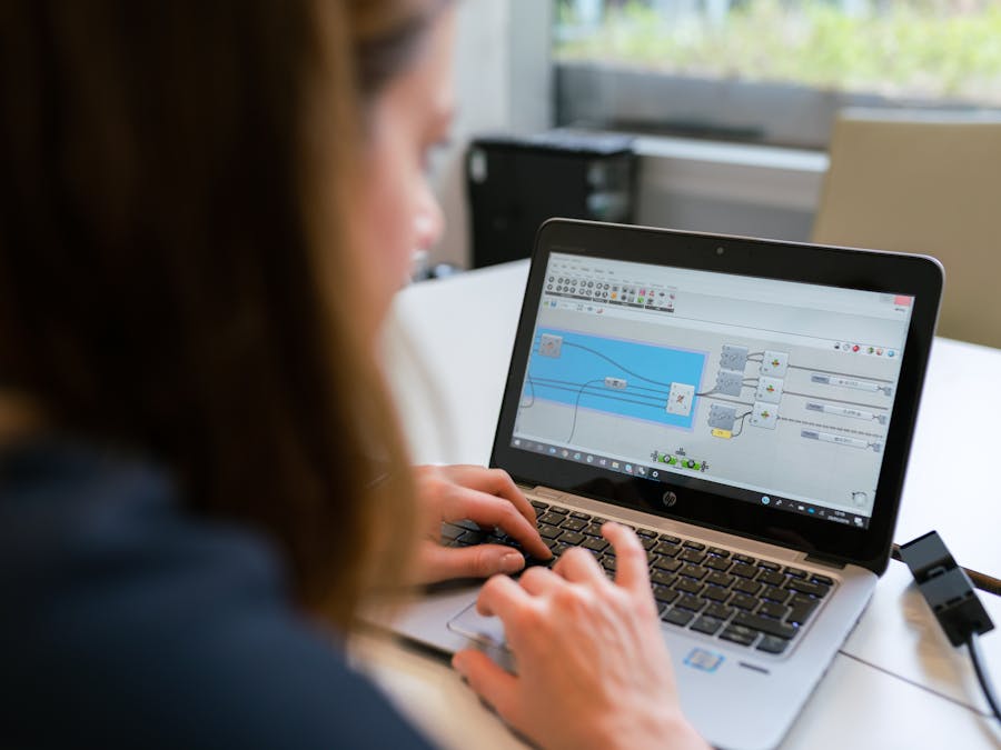 A woman engineer focuses on software analysis using a laptop indoors.