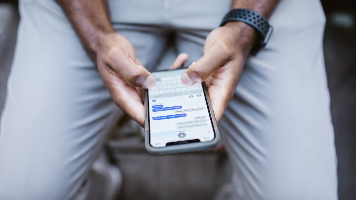 Close-up view of a man texting on a smartphone, capturing communication in action.