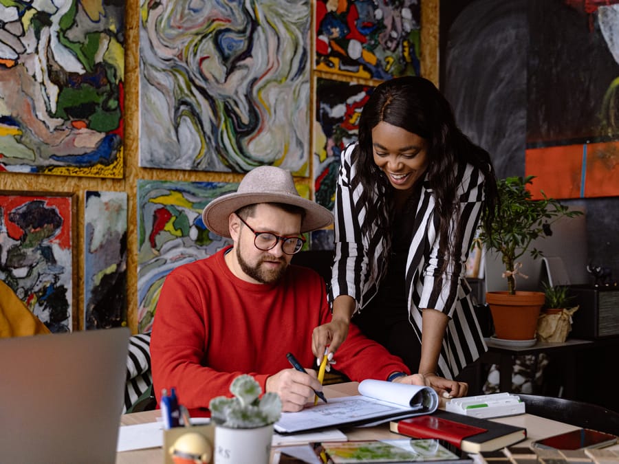 A diverse team working together on an art project in a creative office environment.