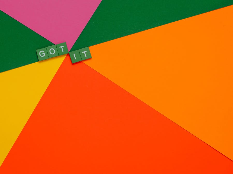 A vibrant abstract design featuring letter tiles spelling 'GOT IT' on colorful paper backgrounds.