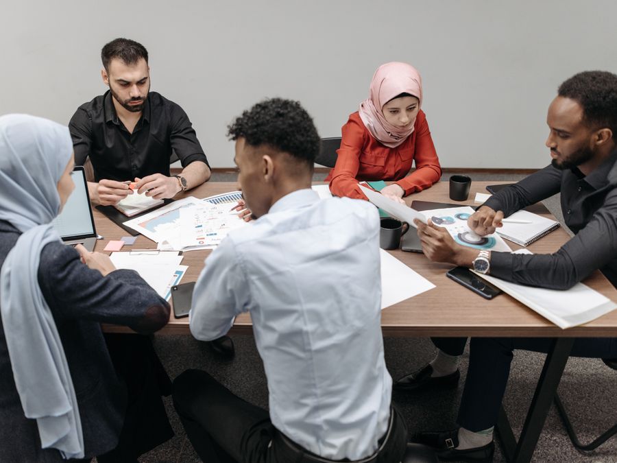 A diverse group of professionals having a collaborative meeting in a modern office setting.