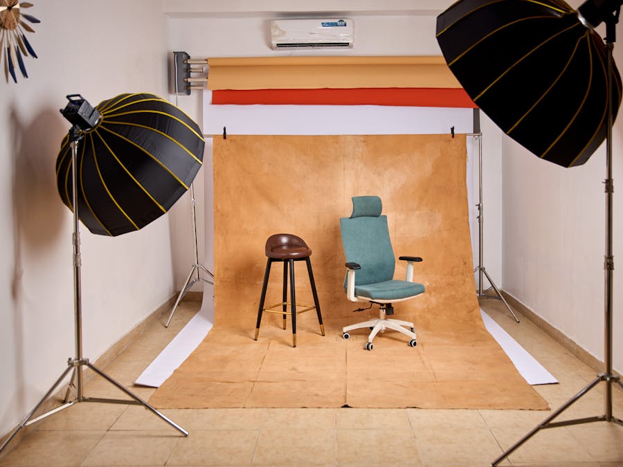 Stylish photo studio featuring lighting equipment and chairs for content creation.