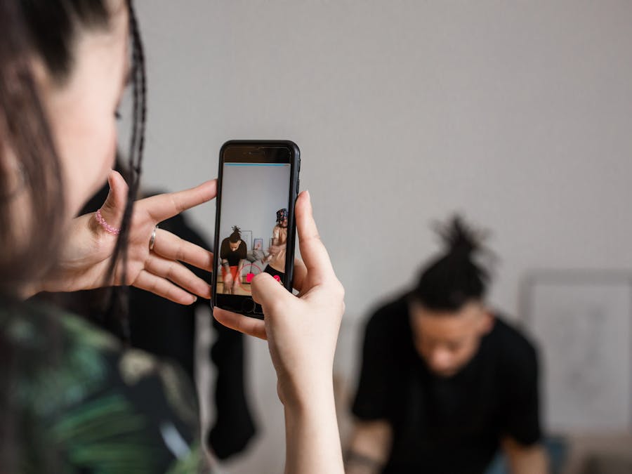 Close-up of a person recording a video with a smartphone indoors, focusing on creative content creation.