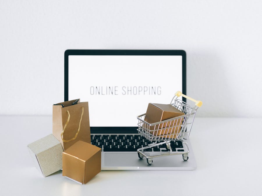 Laptop displaying online shopping with boxes and cart, representing ecommerce.