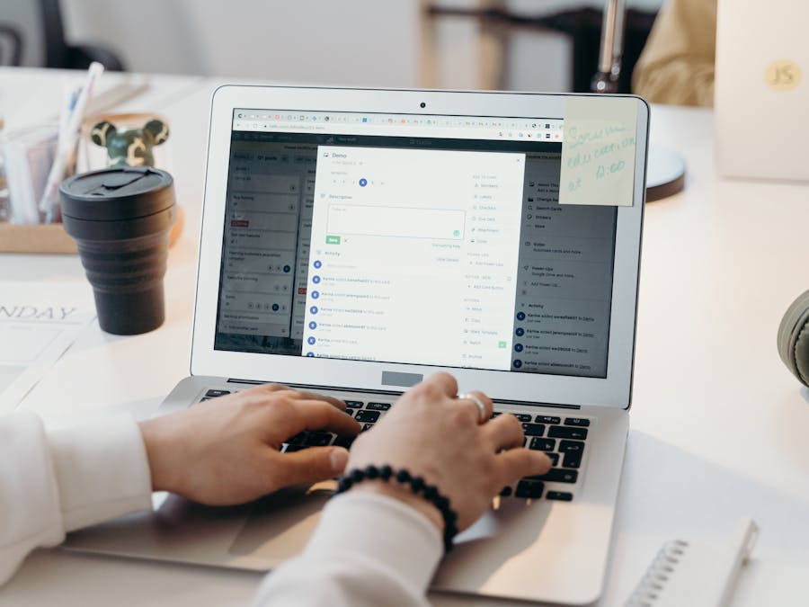 A person typing on a laptop in a bright, modern office setting, showing productivity and technology.