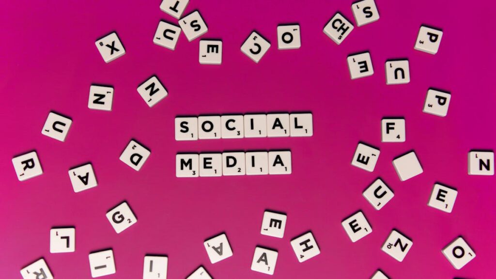 Alphabet tiles forming 'Social Media' on a vibrant pink background, perfect for digital marketing themes.