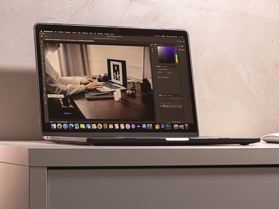 A laptop displaying a photo editing software interface on a clean, modern desk setup.