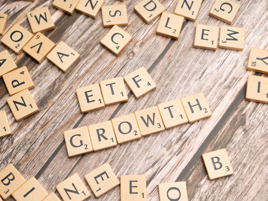 Wooden tiles spelling ETF growth on a wooden surface, symbolizing investment strategy.