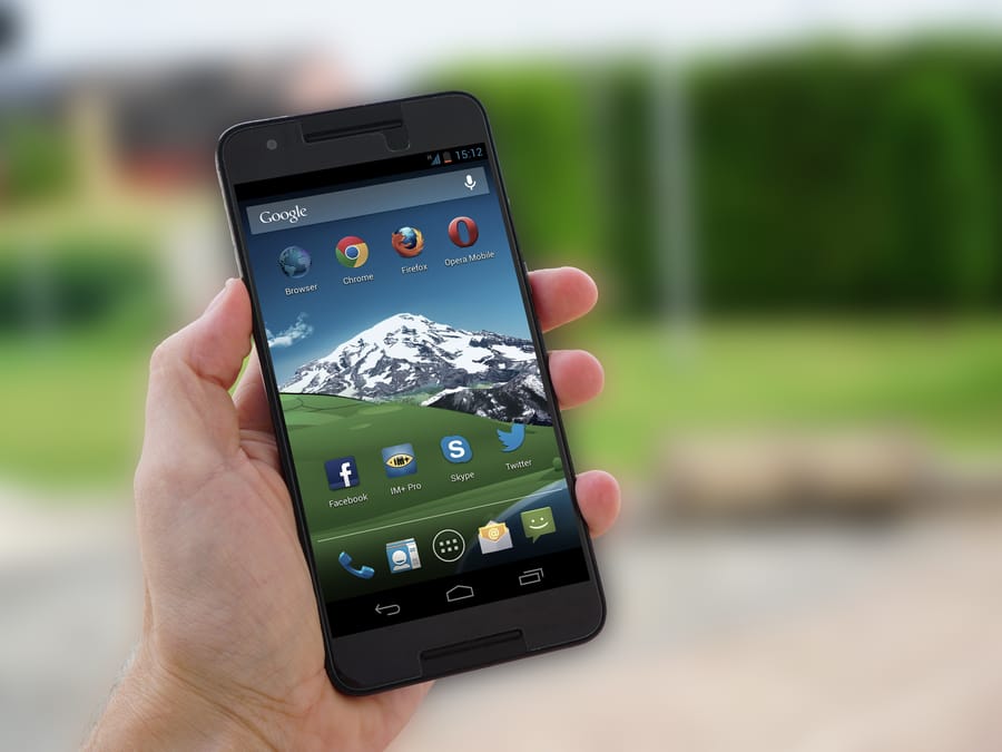 Close-up of a smartphone in hand displaying social media apps on screen.