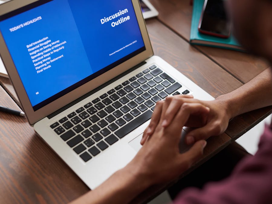A person viewing a business presentation on a laptop screen, ideal for online learning and work settings.