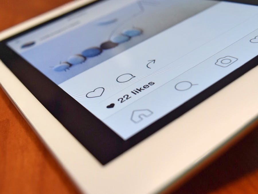 Photo of a tablet displaying a social media app interface with 22 likes, highlighting digital interaction.