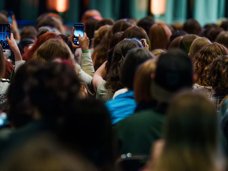 Vibrant crowd capturing live event using smartphones, creating silhouettes and engaging with the performance.