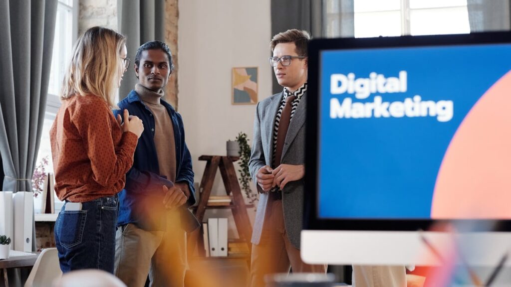 Group of colleagues discussing digital marketing strategies in an office setting.