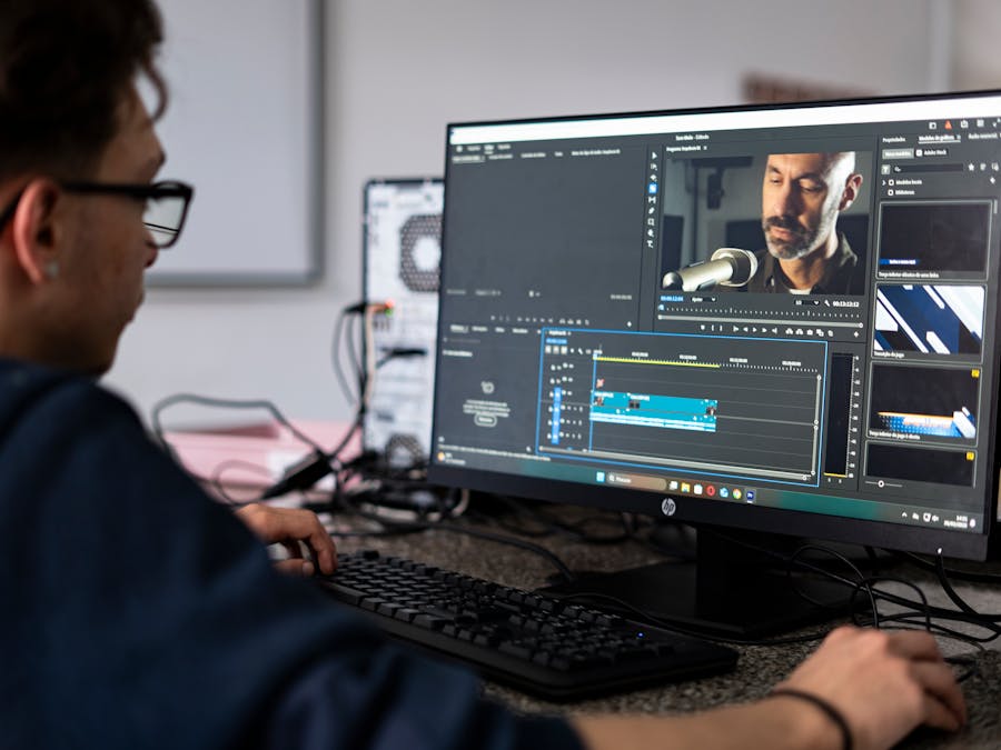 A video editor working on a project using a desktop computer in a modern office setting.