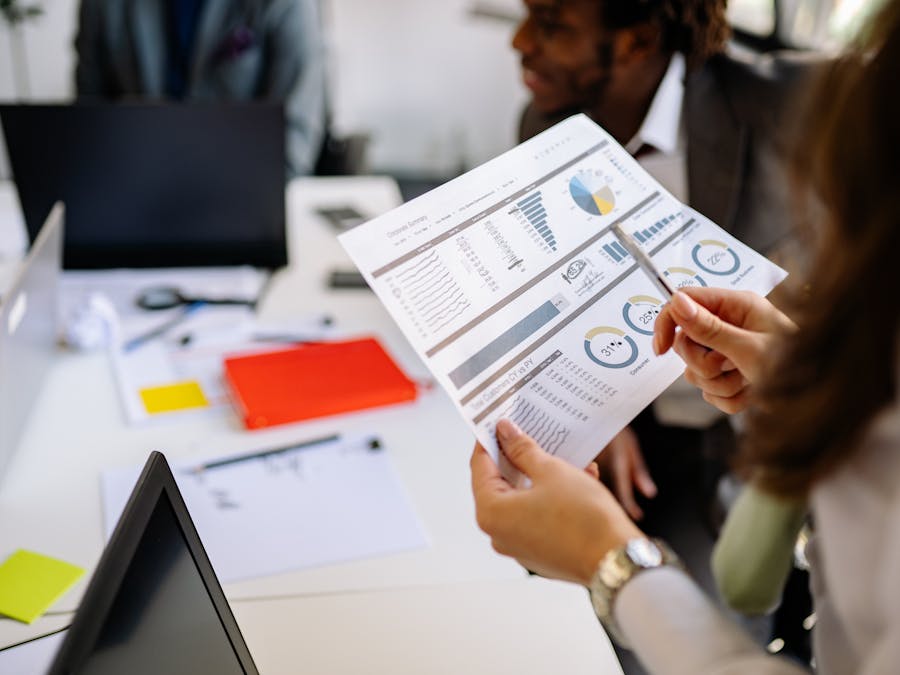 Professionals reviewing business charts and documents in a team meeting.