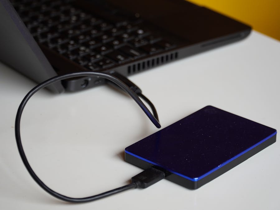 External hard drive connected to a laptop, showcasing portable storage solution.