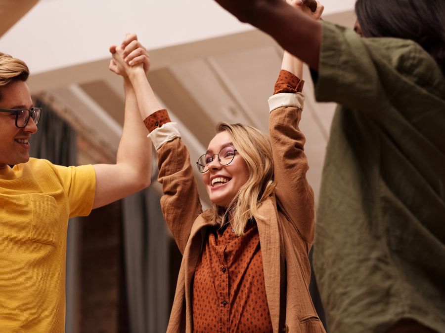 Joyful friends celebrating together with hands uplifted, symbolizing unity and happiness.