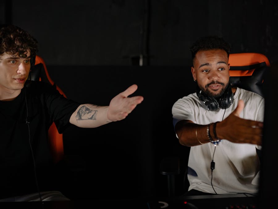 Two men intensely gaming, showcasing teamwork and strategy in a competitive online session.