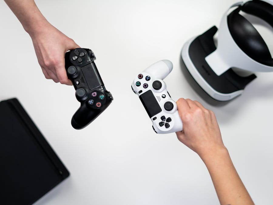 Black and white gaming controllers with VR headset on a minimalist background.
