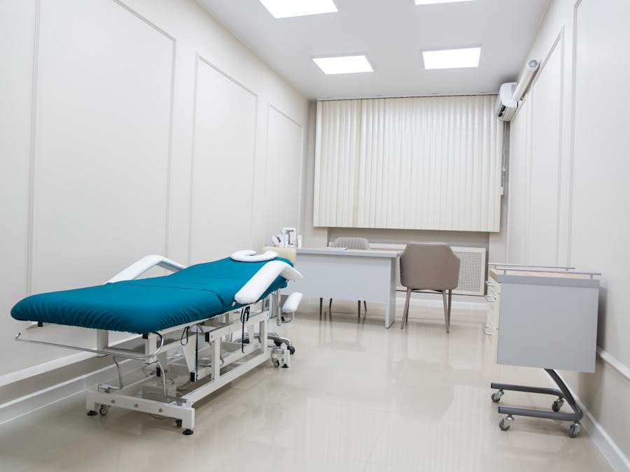 A contemporary medical office interior with modern furnishings, treatment bed, and clean design.