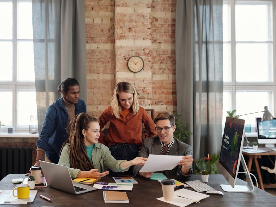 A diverse team of young professionals working on a business strategy in an urban office setting.