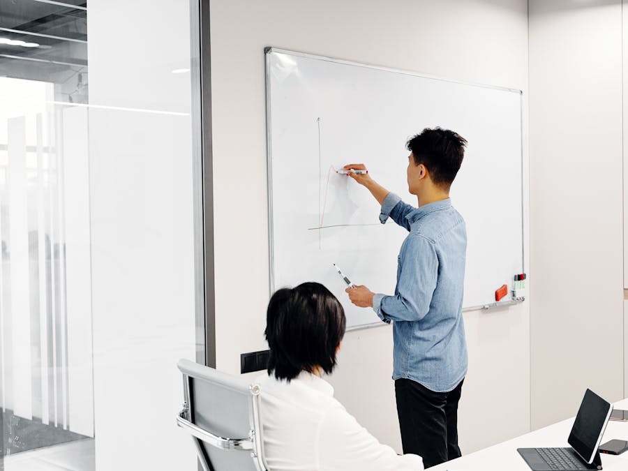 Business professional drawing graph during office presentation with colleague