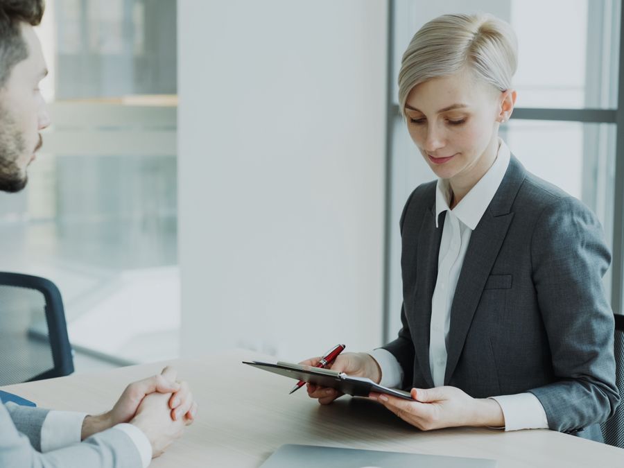 Two professionals in a modern office discussing business. Bright, professional setting.