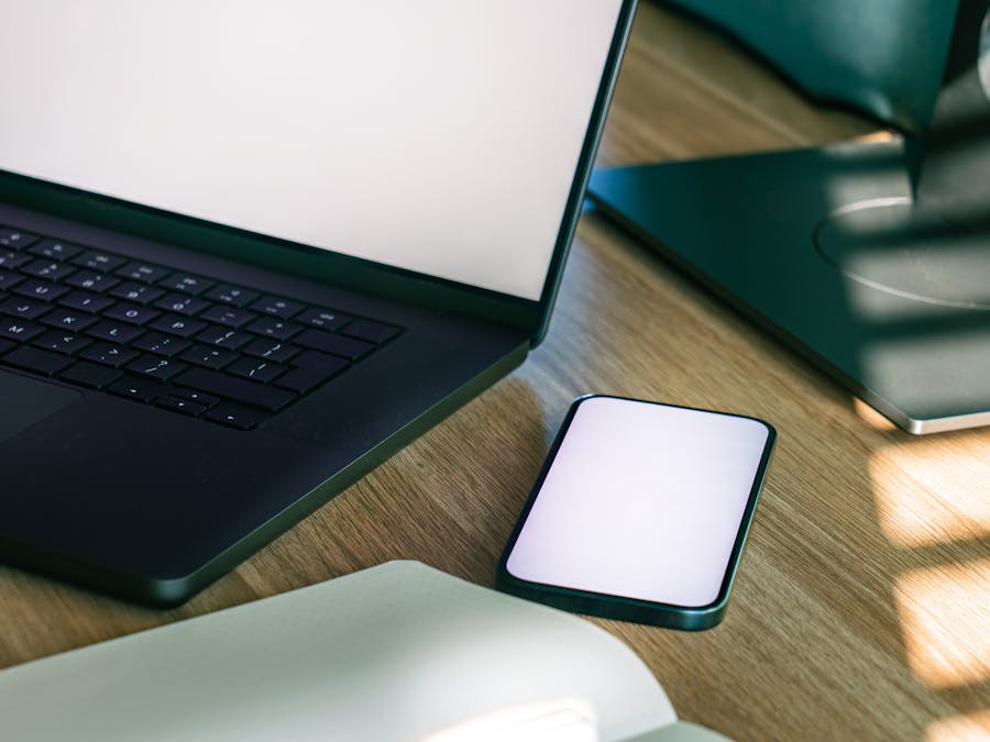 A sleek office desk setup featuring a laptop and smartphone, ideal for tech and business themes.