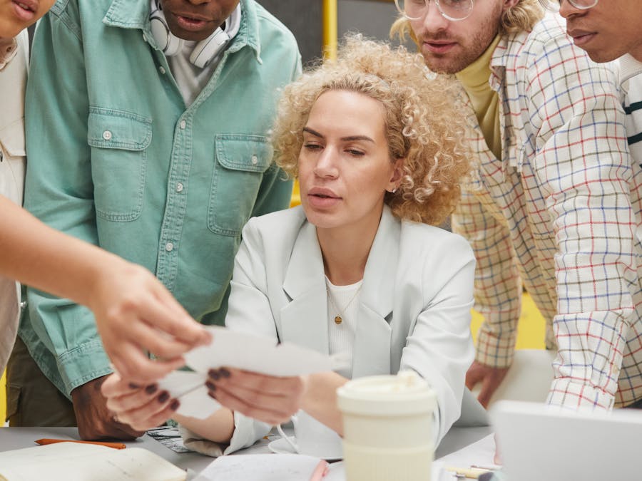 Group of diverse adults collaborating on a project in a modern workspace.