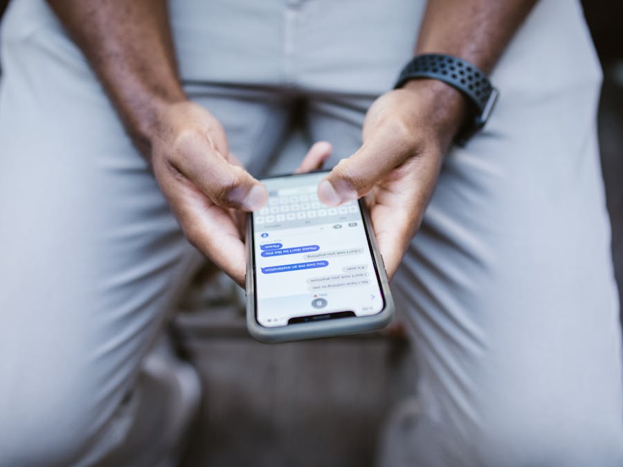 Close-up view of a man texting on a smartphone, capturing communication in action.